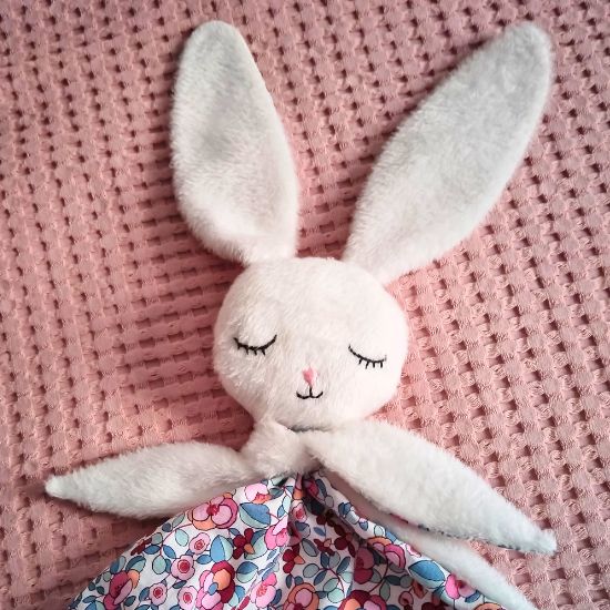 couture d'un doudou plat lapin avec des yeux brodés